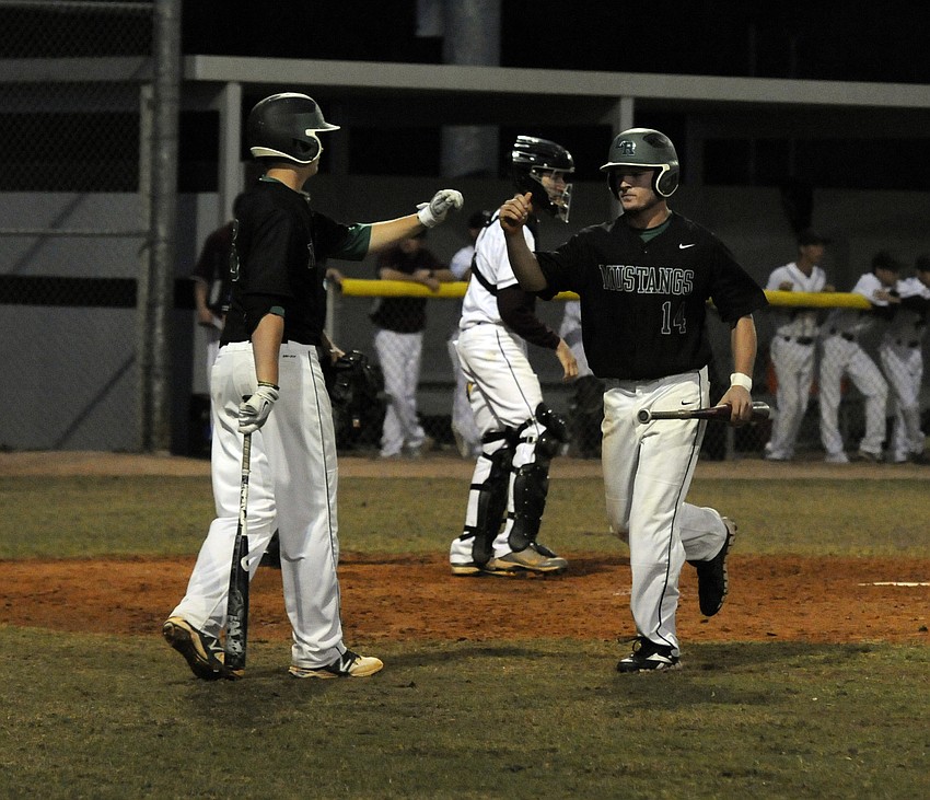 Lakewood Ranchâ€™s Justin Fischer, right, is congratulated by a teammate after scoring the game tying run in the top of the third inning.