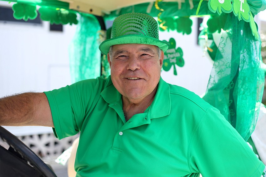 Joe Zampino smiles as he drives a golf cart in the parade.