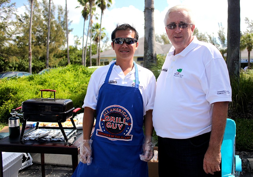 Eric Teoh and Michael Renick, of Mangrove Realty Associates, hand out free hotdogs and chips during the festival.