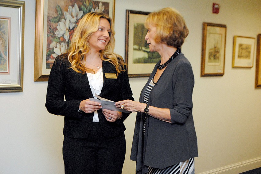 Molly Mishos accepting a grant from Designing Daughters from Burt Minot