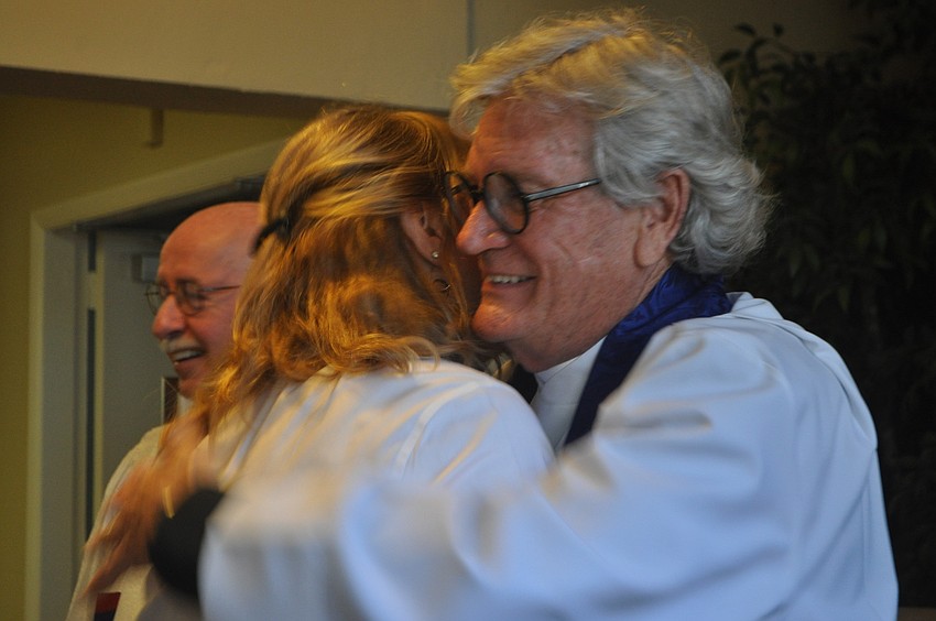 The Rev. Dr. Vince Carroll embraces Laurie Shuttleworth