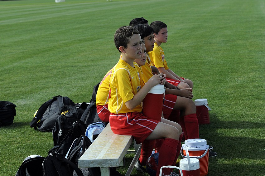 Members of the Lakewood Ranch Chargers U12 team look on as their teammates battle Strictly Soccer April 13.