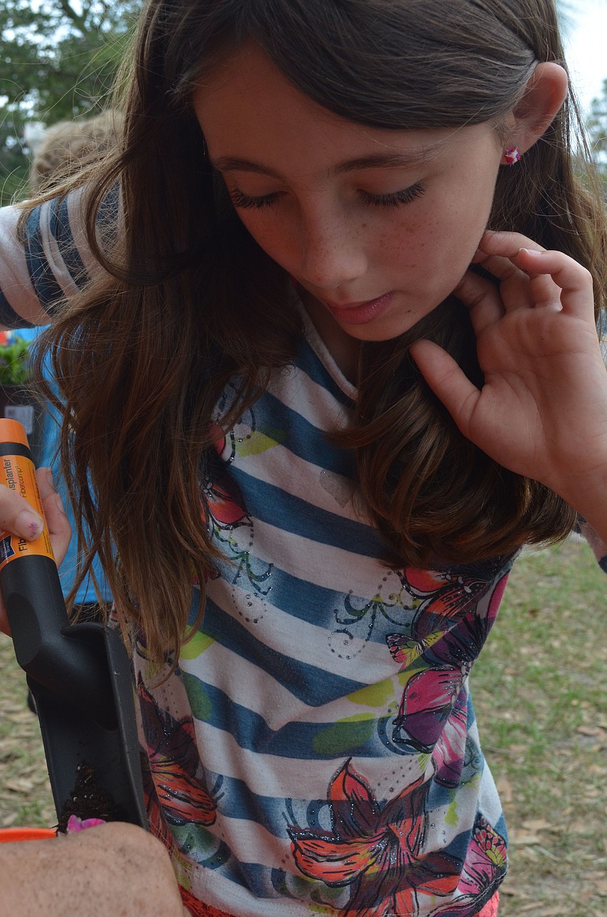 Hailey Pearc learns how to pot a plant.