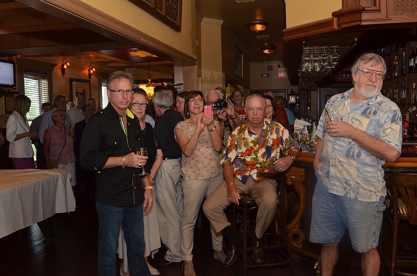 Guests silently wait to surprise Paul Thorpe as he walks through the door.
