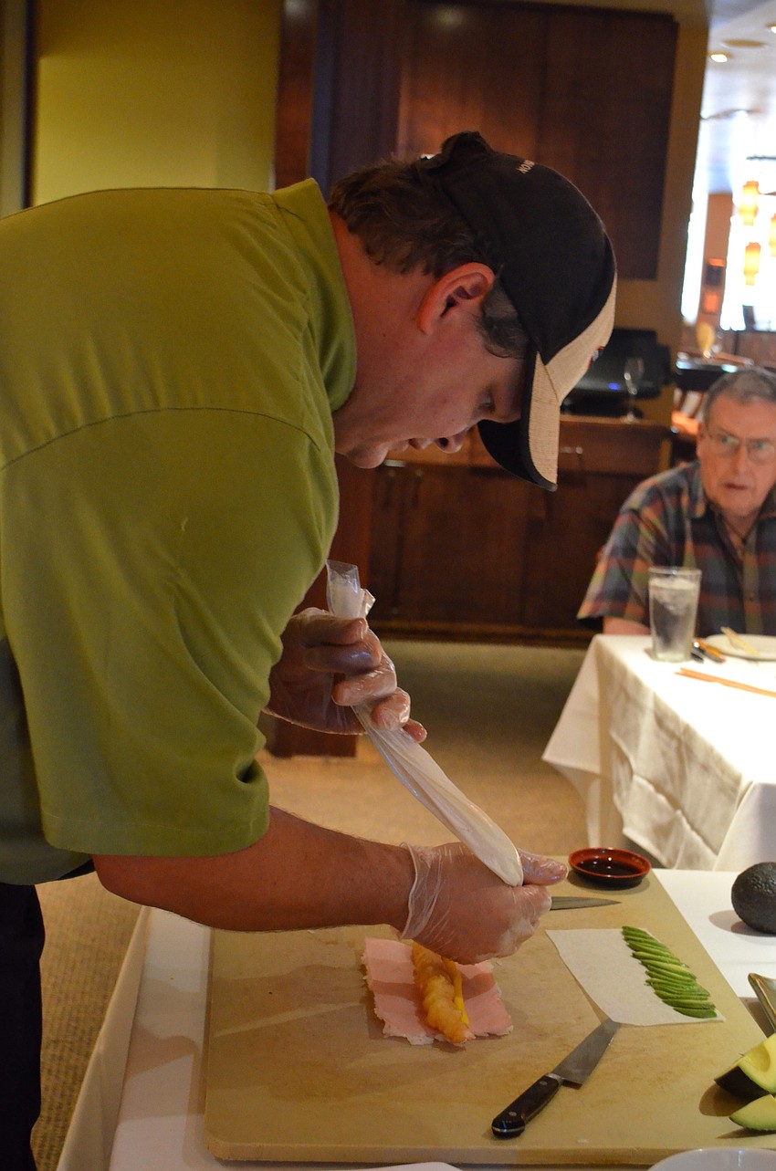 Chef Carl Bertka adds cream cheese to the Ebi roll he demonstrates