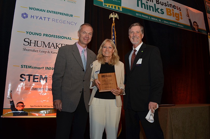 Senior Vice President Chief Financial Officer Martin Lange of Sarasota Bradenton International Airport presents Rudy Weiss and Gabriele Charity of Charity and Weiss International Realty LLC with the International Business Award.