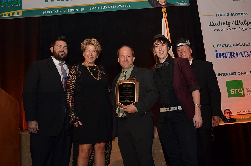 Robert Ludwig of Ludwig Walpole Insurance Agency presents Travis Scheuer his mother Coral Pleas and sister Taelor Sheuer with the Young Business of the Year award.