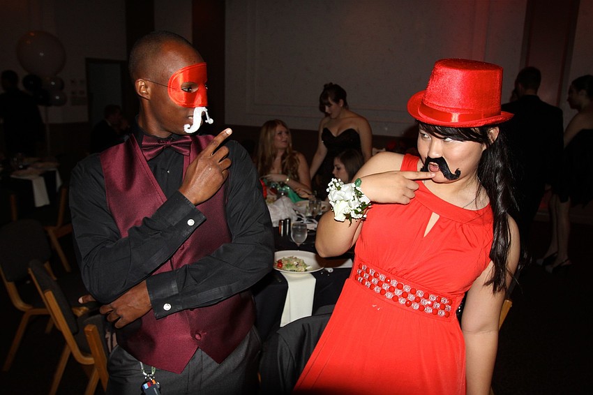 Mark Cochran and Sophie Biederman have some fun with the props at their table.