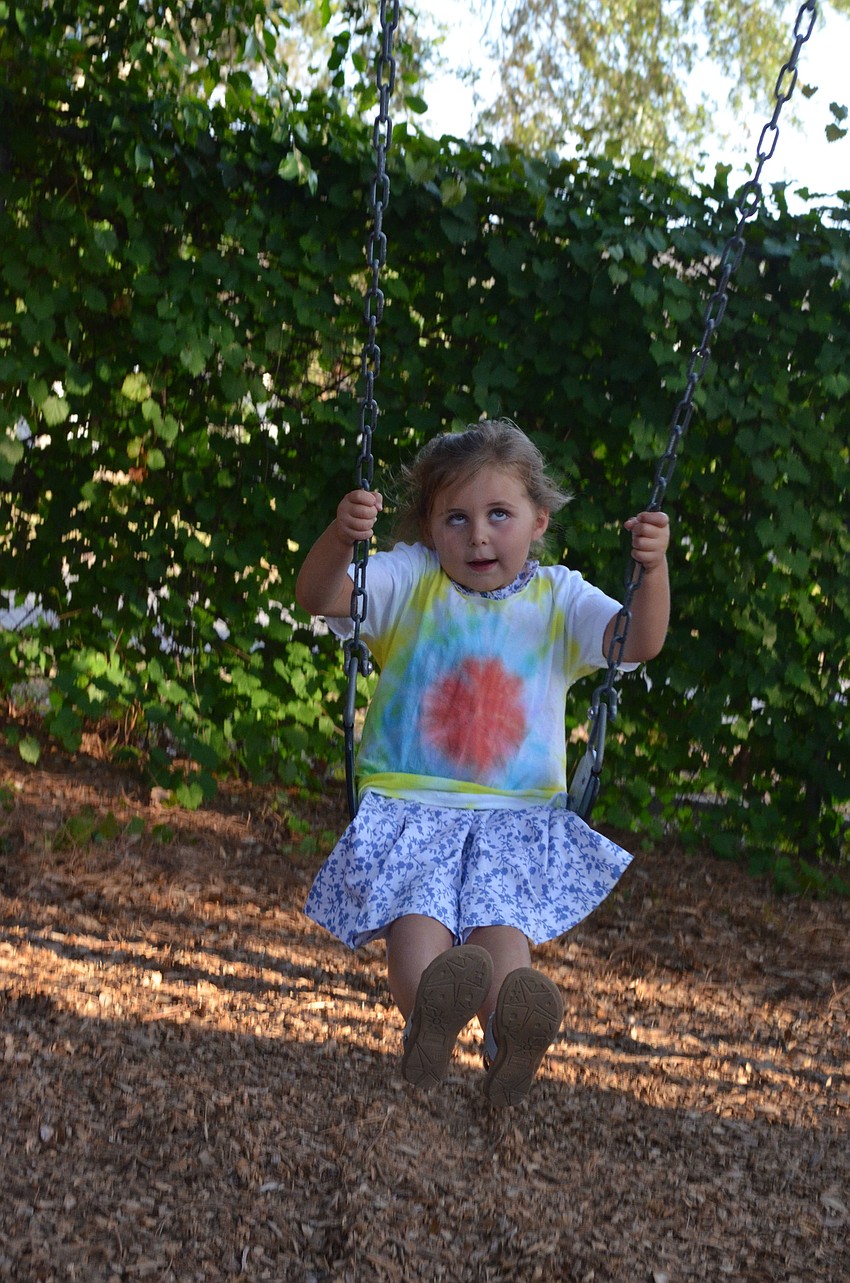 Arianna Benson swings on the swing set after her graduation.