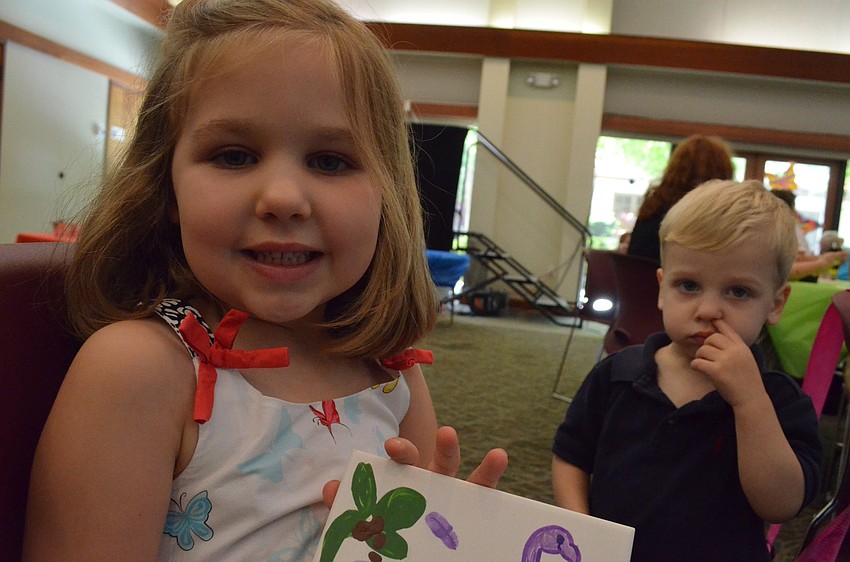 Lauren Marvel shows of the tile she made with her parents as her little brother Kensley looks on.
