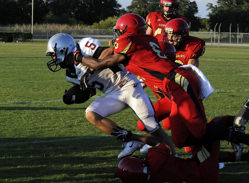 Braden River wide receiver Austin Fox is wrapped up by Cardinal Mooney defensive back Sean Morris.