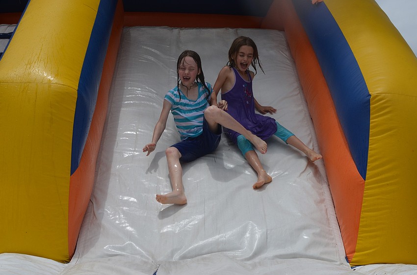 Twin sisters Rachel and Ella Cummings have a blast going down the slippery slide.