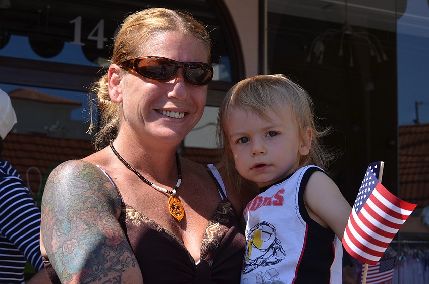 Angela Osuba and her son Logan watched the parade pass by and waved their American flag.