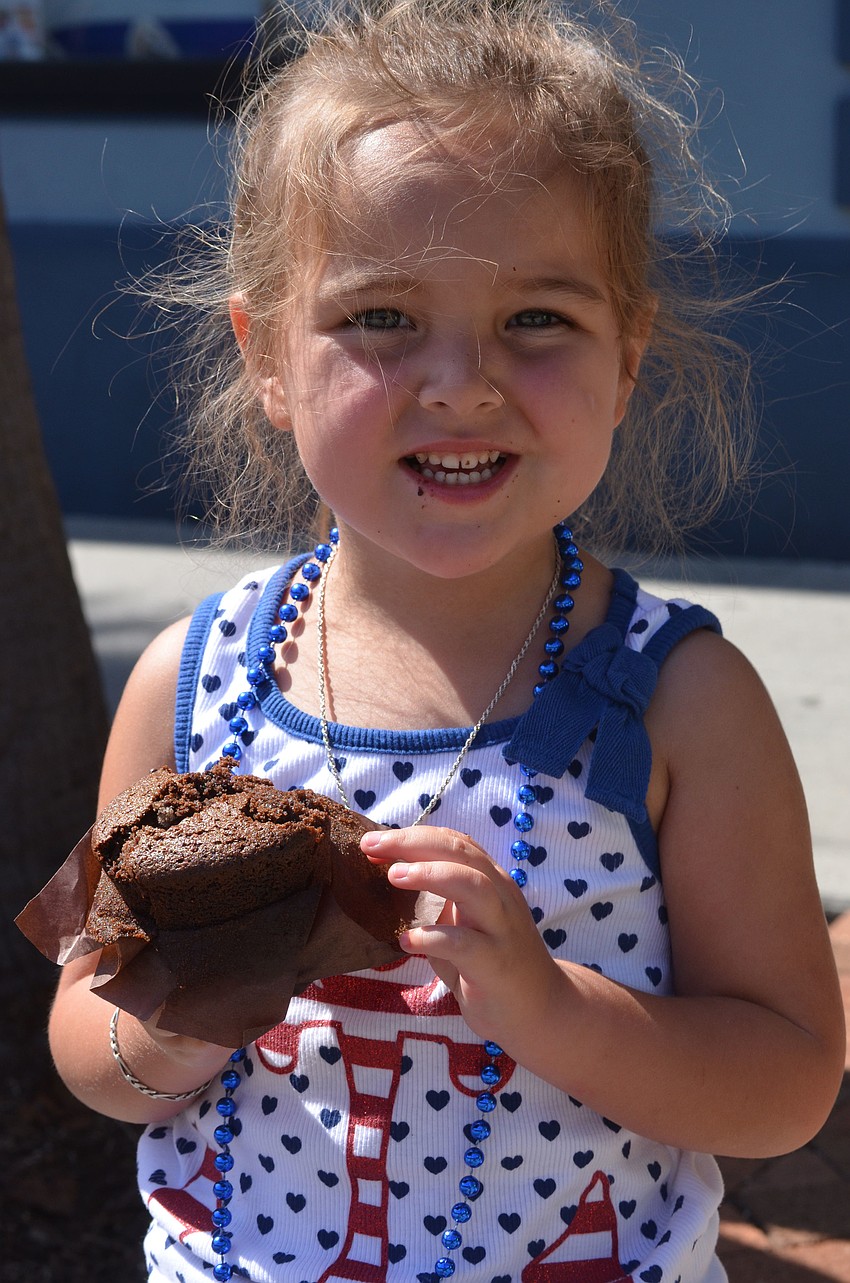 Three-year-old Chloe Clements munches on a brownie from Whole Foods during the parade.