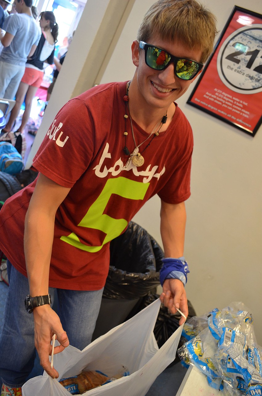 Senior Thomas Pring collects sandwiches in bags.