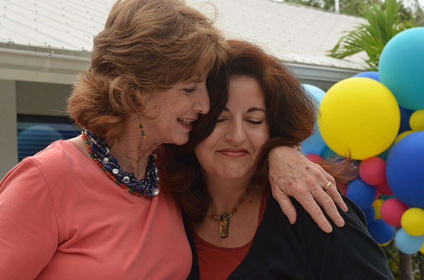 Glendy Huene thanks Alyssa Mandel for the torsade necklace she made her. Mandel and Huene worked hand in hand as the schoolâ€™s librarians.