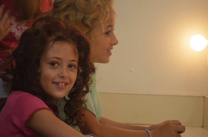 Alexandra Hernandez and Julia Koren check out their new look in the mirror.