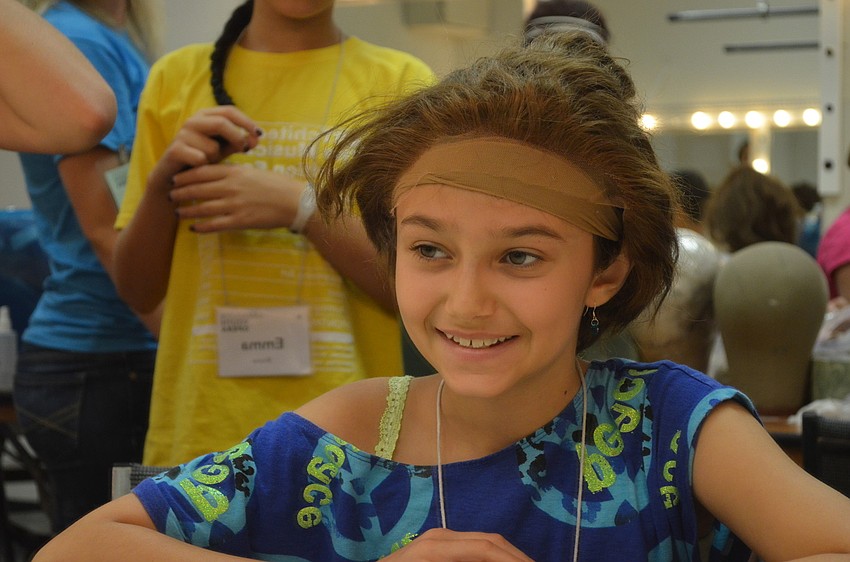 Lauren McLean checks out her new look in the mirror during wig class. Children got a chance to learn about wig making and tried on various wigs used in operas.