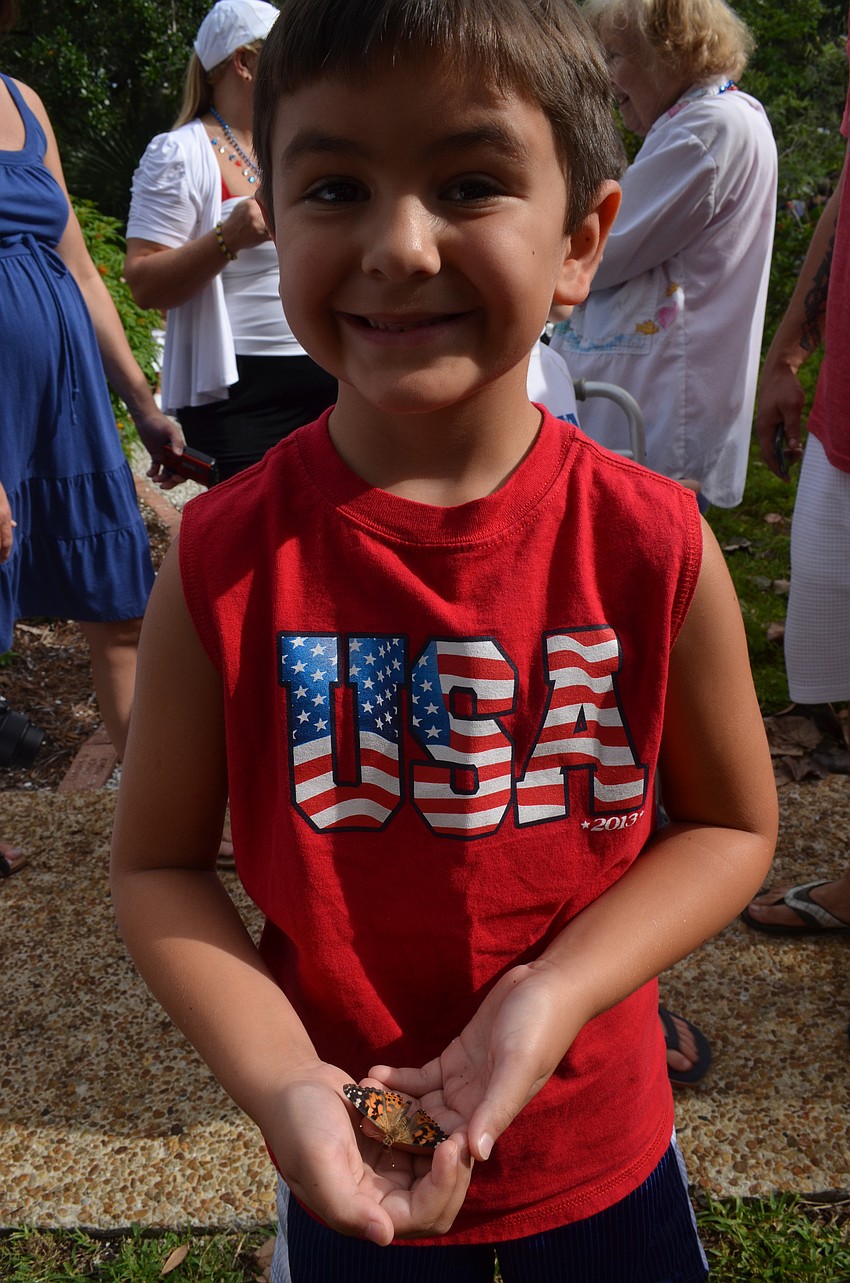 Aidan Shoulson, 7, releases a butterfly into the butterfly garden at Freedom Fest.