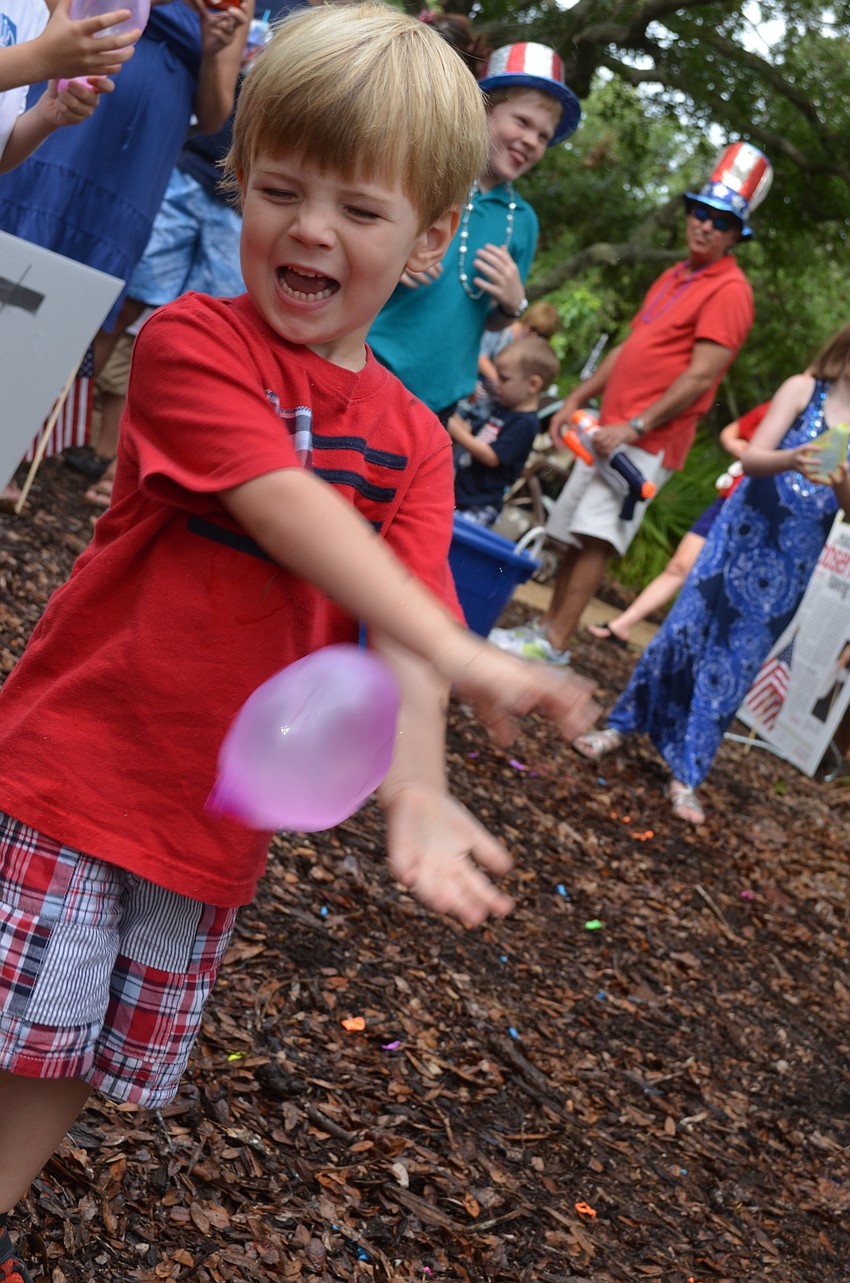 Rhys Parry, 3, tries to catch a water balloon during the water balloon toss.