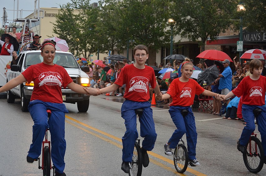 The Sailor Circus rides unicycles in the parade.