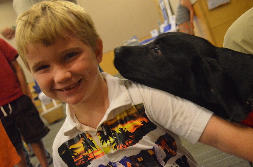 Matthew Dye, 7, gets his ear licked by 17-week old puppy Kaleb.