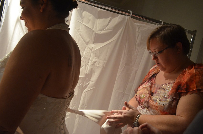 Caroline Franco tries on a wedding gown at the Brides Against Breast Cancer â€¨Charity Wedding Gown Sale & Bridal Show.