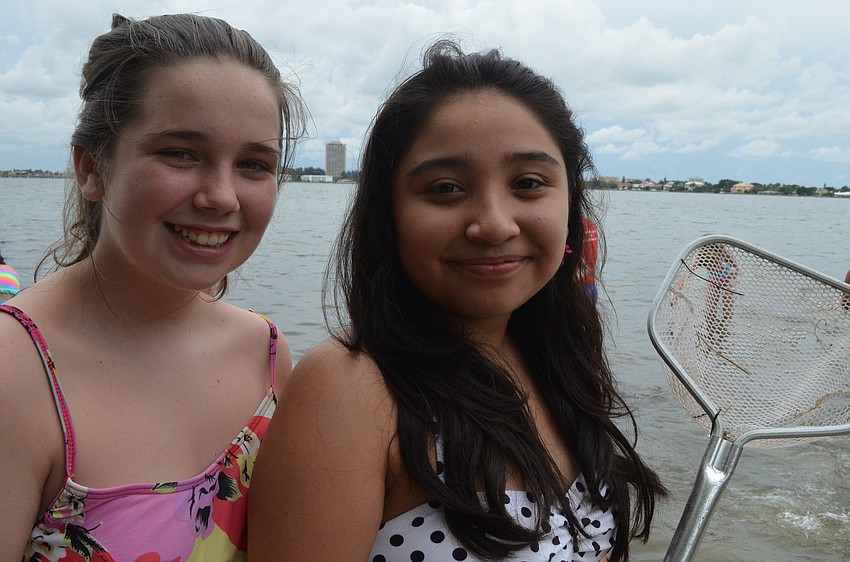 Payton Saturen and Geovanna Romero search for critters.