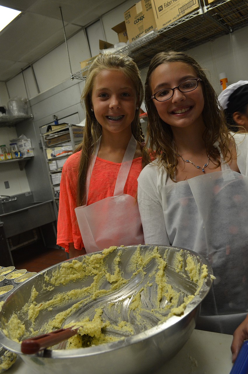 Samantha Reisky, 11, and Josie Filipanits, 10, prepare food to show guests what they learned at camp.