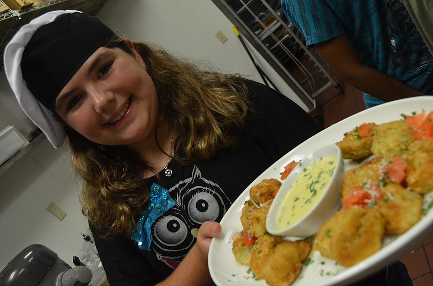 Valerie Wojcik, 10, brings out artichokes esther-style to guests.