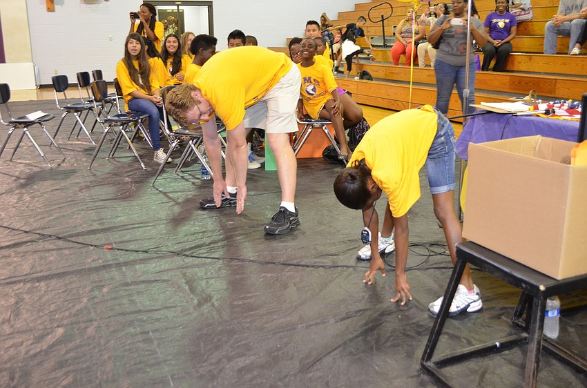 Fitness teacher James Leggett and Jaela Dennis teach the Booker Middle School staff proper stretching technique.