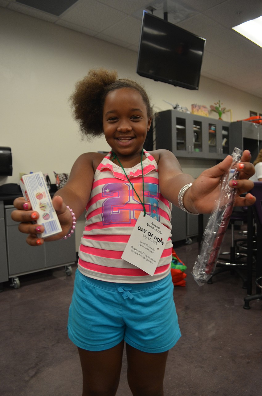 Tanityah Gipson, 9, gets a goody bag with a toothbrush and toothpaste. She got her teeth checked and fluoride put on them at the Fifth Annual Day of Hope. Taniyah will be back at Tuttle Elementary in August.