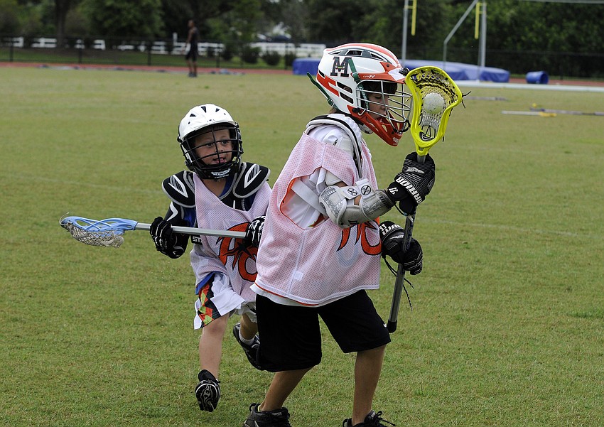 Five-year-old Mickey Cohen tries to keep 10-year-old Eli Newman from maneuvering back toward the goal.