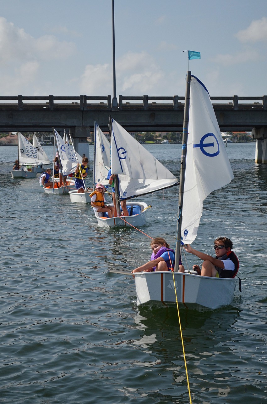 A pontoon boat pulls the campers to calmer waters for sailing.