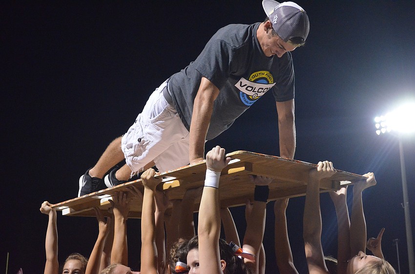 Senior Dylan Busby does push-ups for every point the Sarasota Sailors score as cheerleaders hold him up.