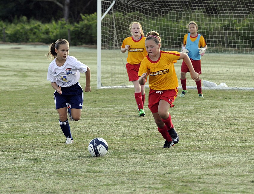 Eleven-year-old Peyton Kovatch, right, pushes the ball up the field for the Clearwater Chargers U11 team.