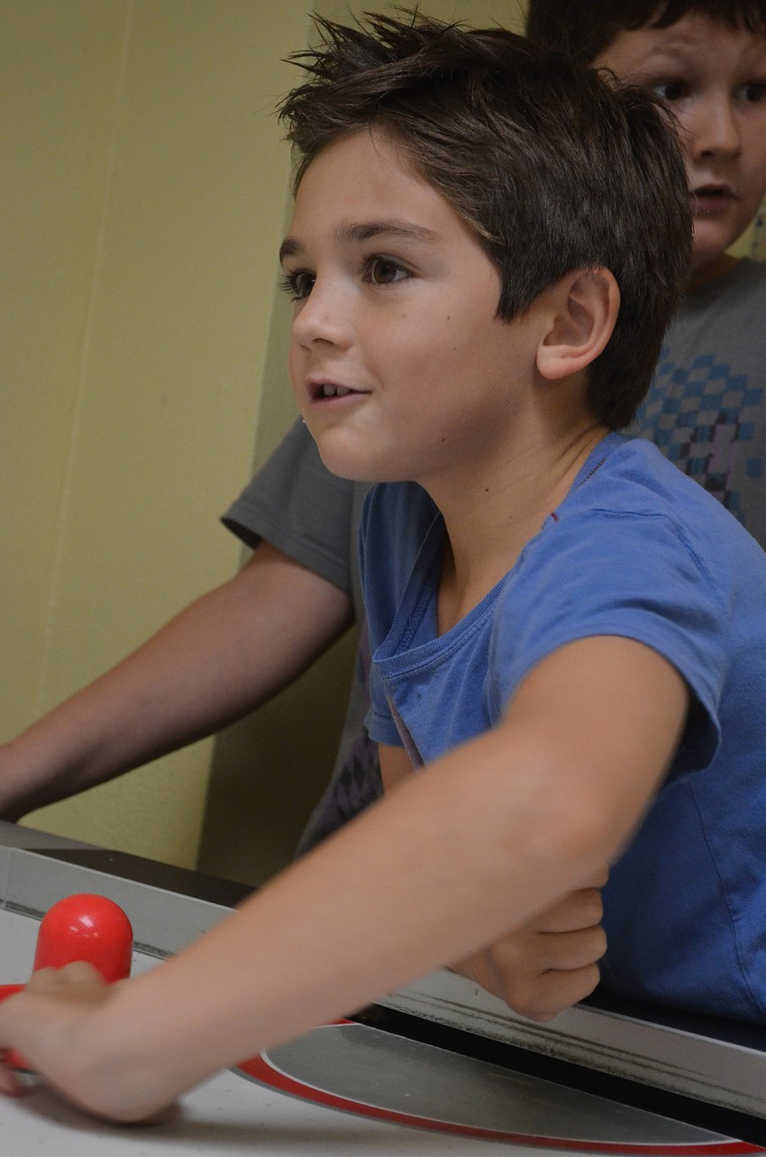 Rocco Rel, 7, plays air hockey.