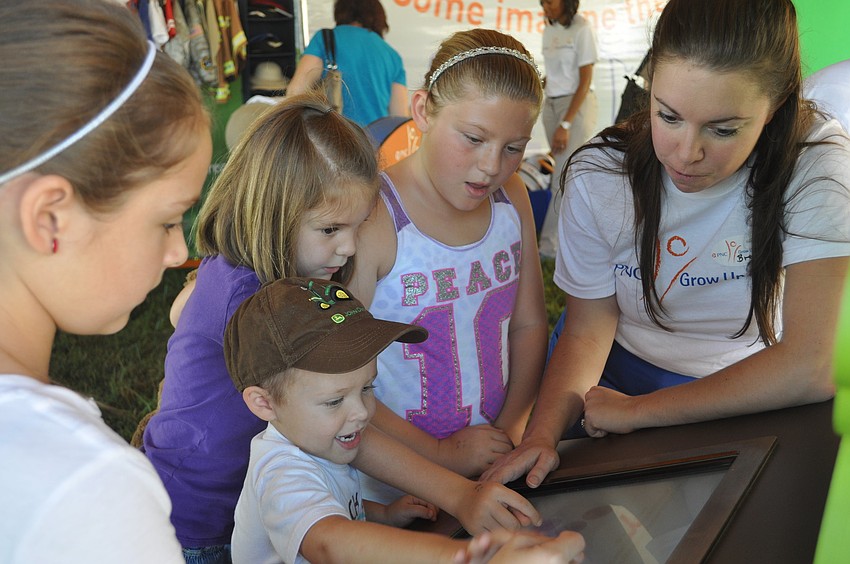 Madison, T.J. and Savannah Carter with Samantha Scheiber play and learn on the PNC Mobile Learning Unitâ€™s kiosks