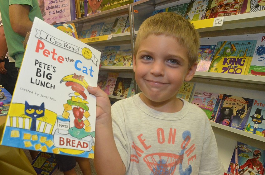 Nicholas Lewis, 4, chooses a book to purchase at the fair.