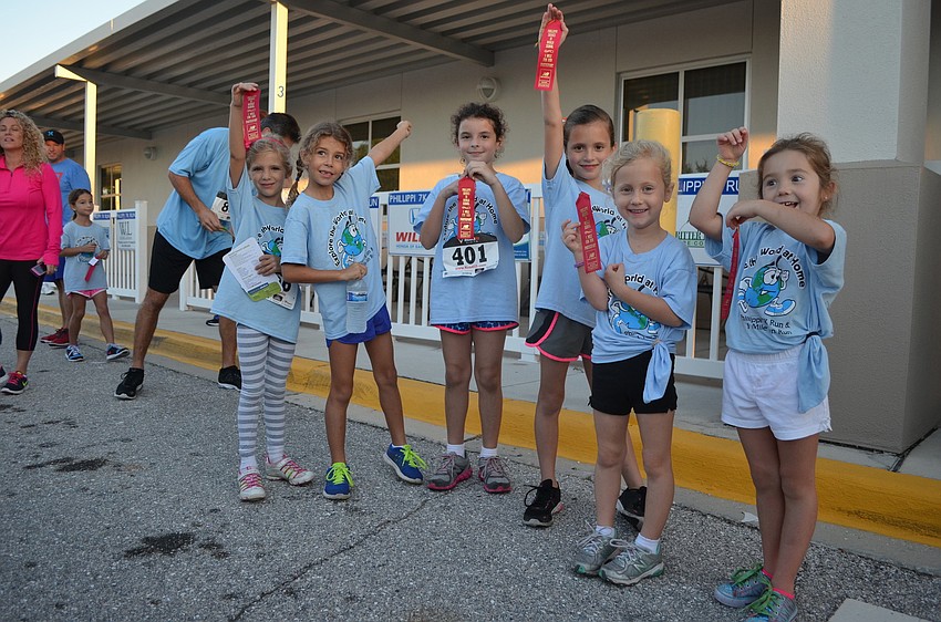 Alyssa Wright, Sophia Constantino, Maci Steinfeld, Sophie and Anna Buchmeier and Riley Roads show off their ribbons from the race.