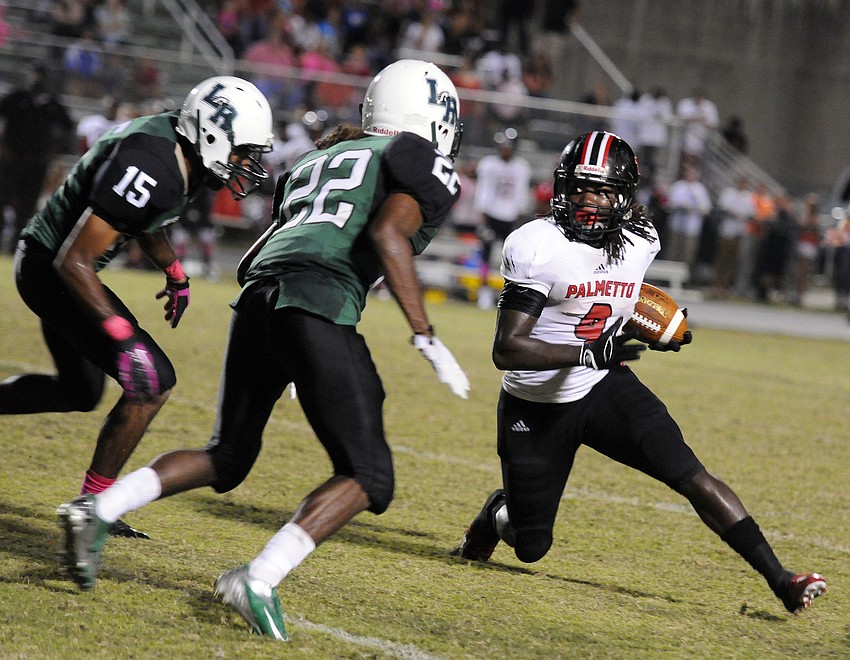 Lakewood Ranchâ€™s Daniel Perjuste and Brandon Luckett contain Palmetto running back Joshua Hicks.