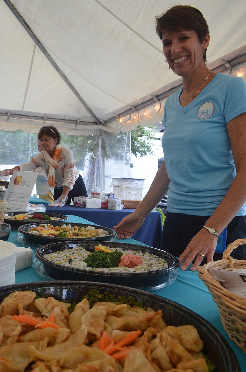Prevention Educator at Child Protection Center Nelda Litwiller volunteers to serve sushi to community members.