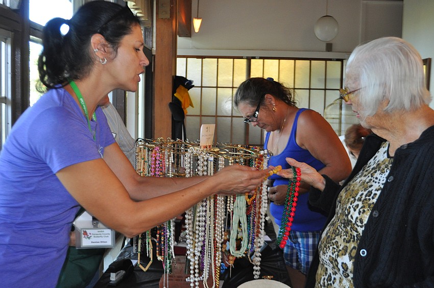 Denise Etten helps Carol Metcalfe choose a necklace
