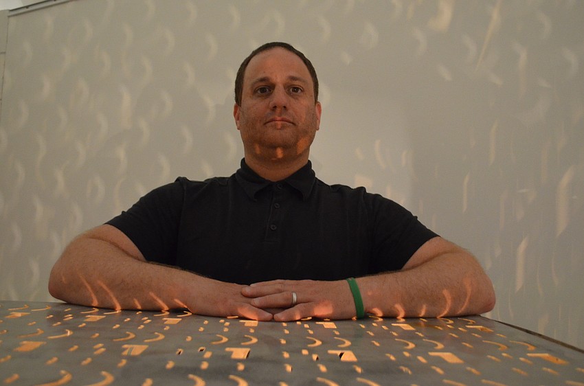 Artist Craig Colorusso with one of his six CUBEMUSIC metal cubes. Each projects a different four-note chord as well as light from different shaped cut holes.