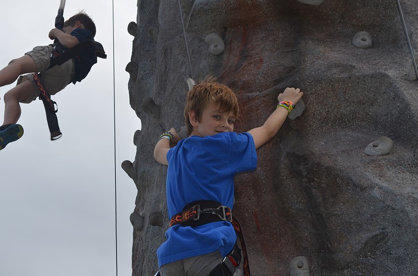 Liam Hugglestone climbs the rock wall.