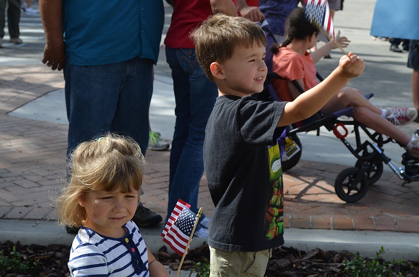 Cousins Olivia Guido and Jacob Melvino wave their flags.