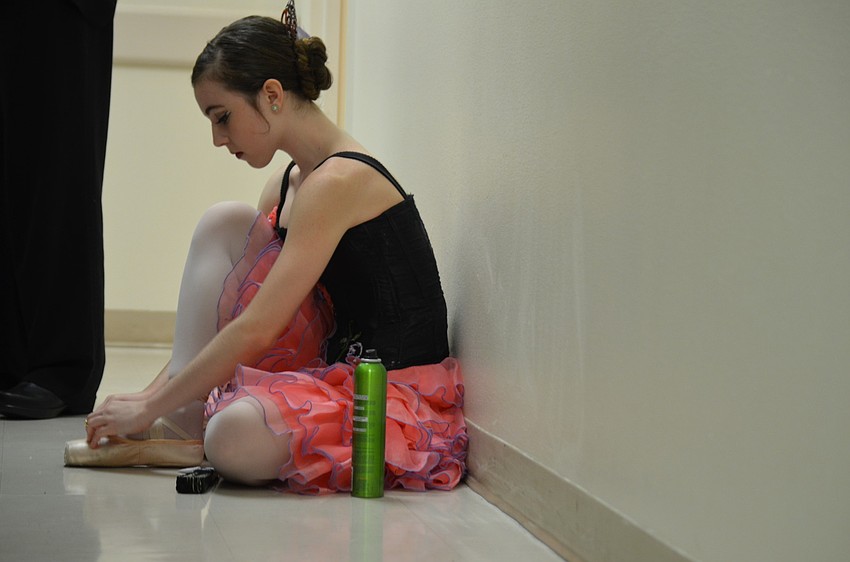 Allison Forsyth adjusts a shoe backstage before the performance