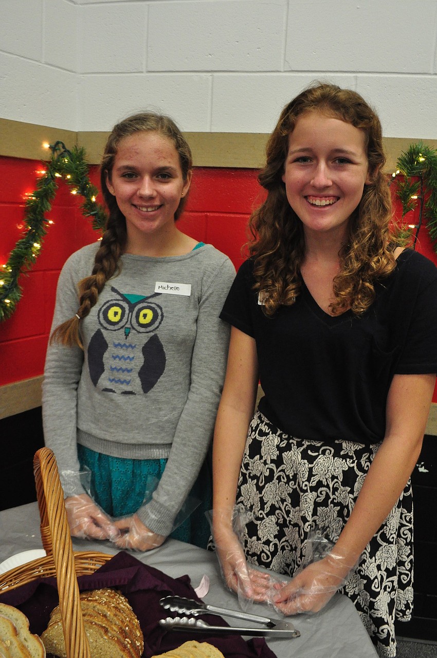 Michelle Sobolewski and Elizabeth Gape serve bread donated by Publix.