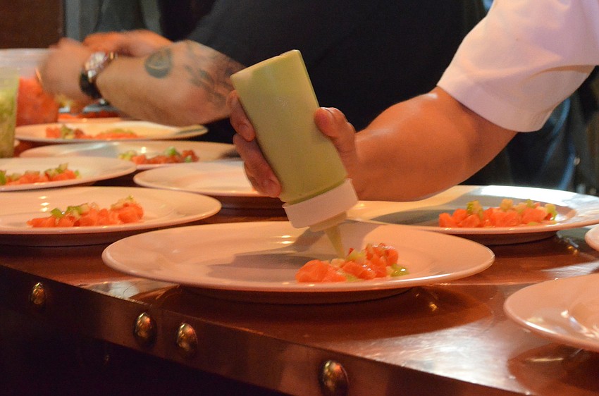 The final touches are added to the first course of the Celebrity Chef Tour Dinner.