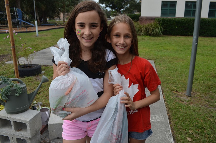 Melanie Green and Graycen Schwartz take home carrots and kale.